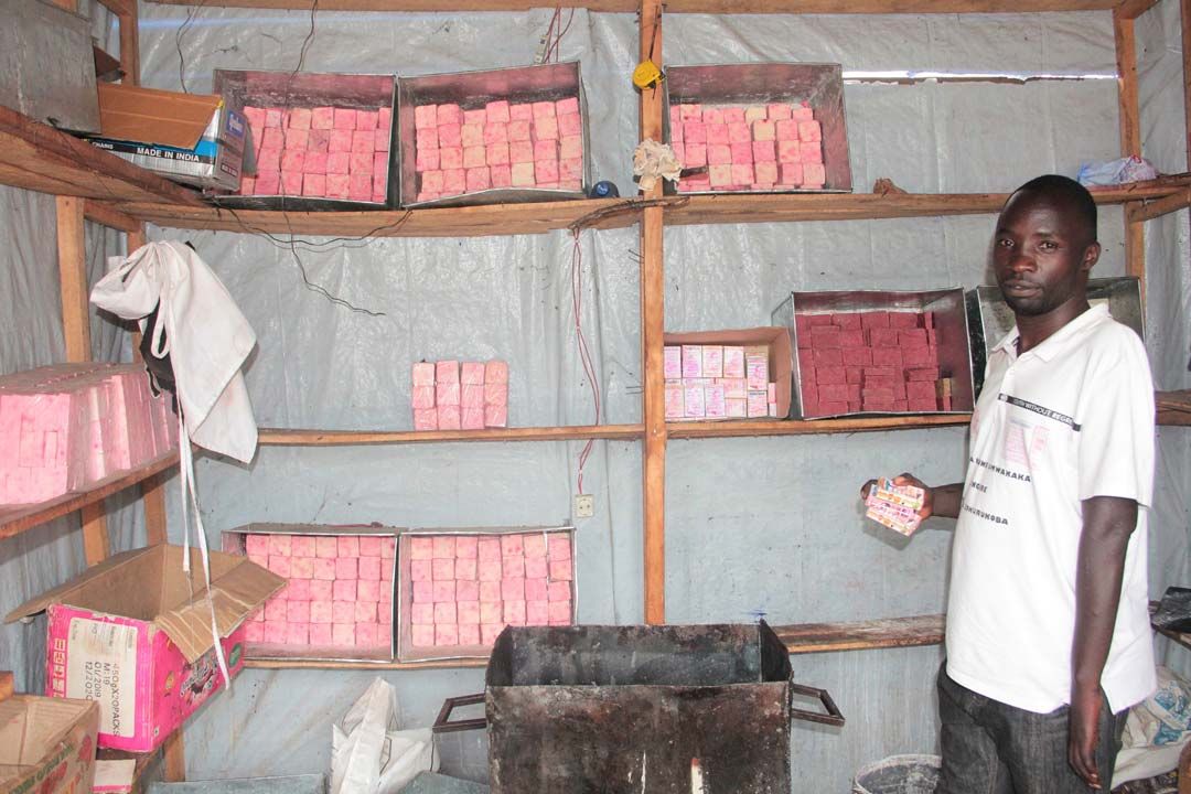 Baseka Saidi Vianney holding in hand ‘’Umwakaka soap’’ in his shop for soap